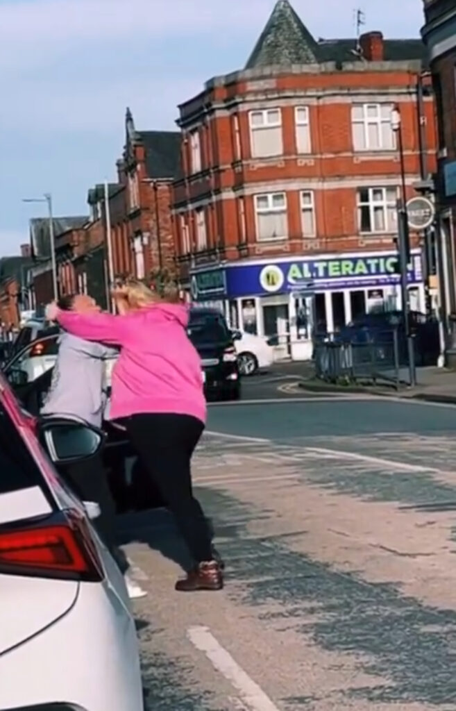 The two women grappled in the middle of the road.