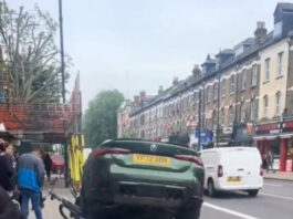 The crash somehow left the BMW balanced in the air on top of one of it's wheels.