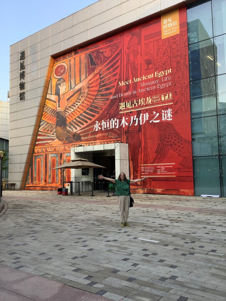 Caroline Dempsey standing in front of exhibition building in China.