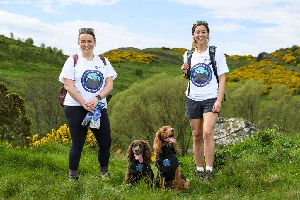 Annie Wheeler, Hollie Jenkins and her two dogs on a hill.