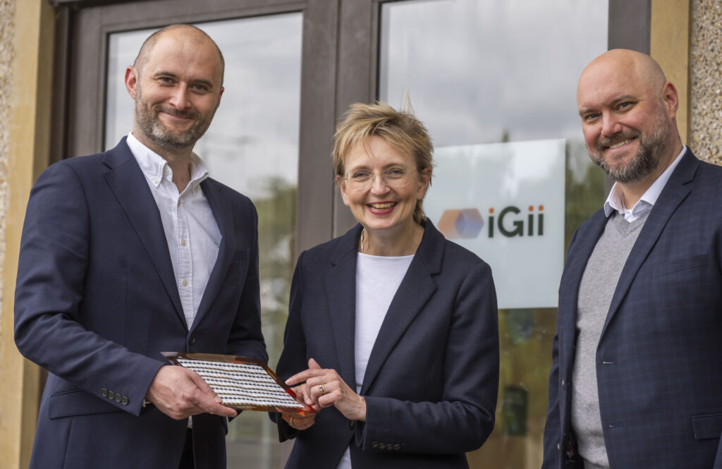 iGii CEO with two investors holding a sheet of Gii-Sens nanomaterial.