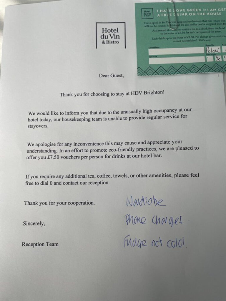 An image of a letter with black text on white paper from a hotel apologising for its lack of housekeeping services and offering a £7.50 drinks voucher per person. The voucher is green with black and white text, and is attached to the letter with a paper clip.