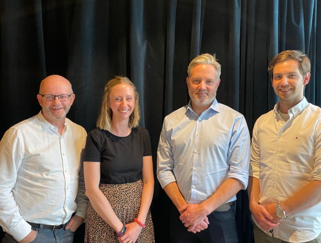 Four out of the five staff members smile in a photo. Image supplied with release by Acumen