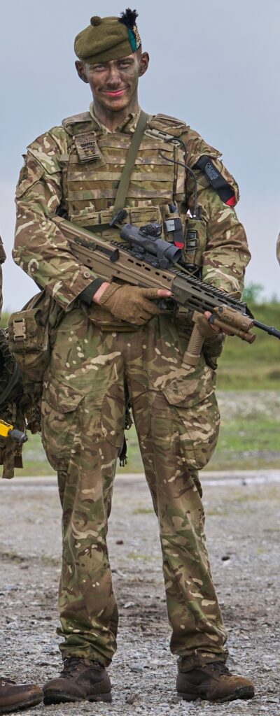 A young man with camouflage face paint wearing a camouflage military uniform, holding a rifle.