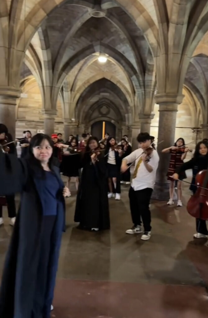 The orchestra played the tune amongst architecture resembling Hogwarts.