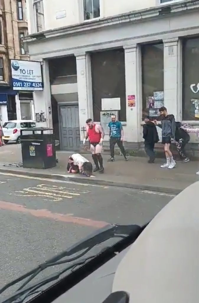 SCOTS witnessed a bizarre impromptu wrestling match unfold on a Glasgow street as two costumed “lunatics” put on a show.