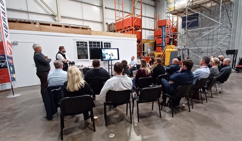 An image of a presentation being given inside an industrial building.