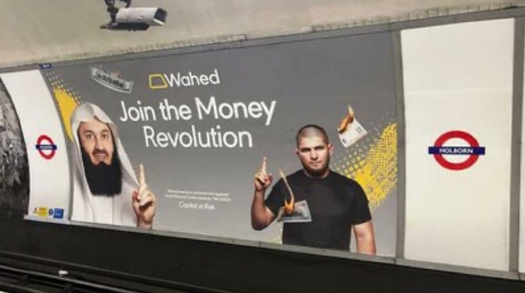 An image of a poster in a London Underground station featuring images of two men and burning dollar bills. It reads: "Join the Money Revolution."