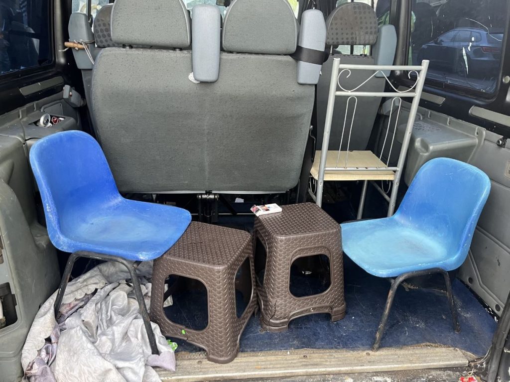 An image of five plastic chairs unsecured in the back of a minibus.