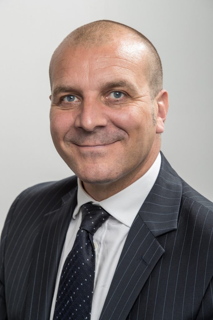 A headshot of a man wearing a suit and tie.