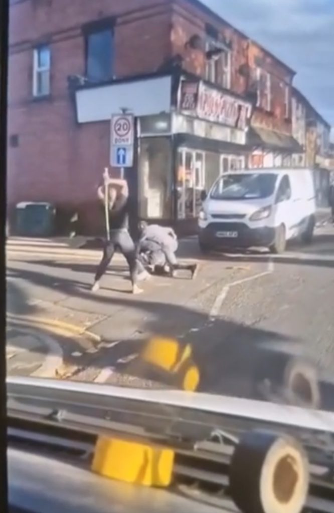 HORROR footage shows a mass brawl breaking out in the middle of a street as a group of blokes – armed and otherwise – beat each other savagely.