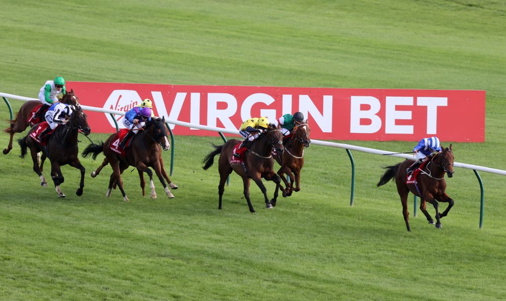 Horses racing with the Virgin Bet sponsorship ad visible in the background.