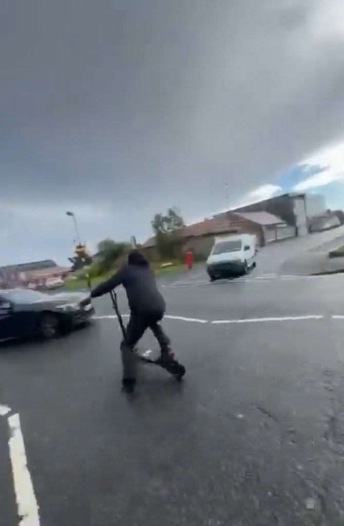 THIS is the horrifying moment a young lad is filmed speeding down a busy residential road on an e-scooter before smashing headfirst into a BMW.