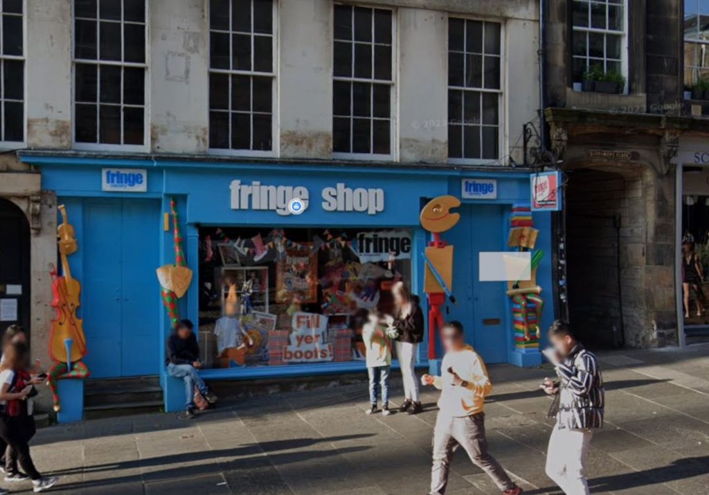 An image of a blue-fronted unit in an old building, with a sign reading "fringe shop"