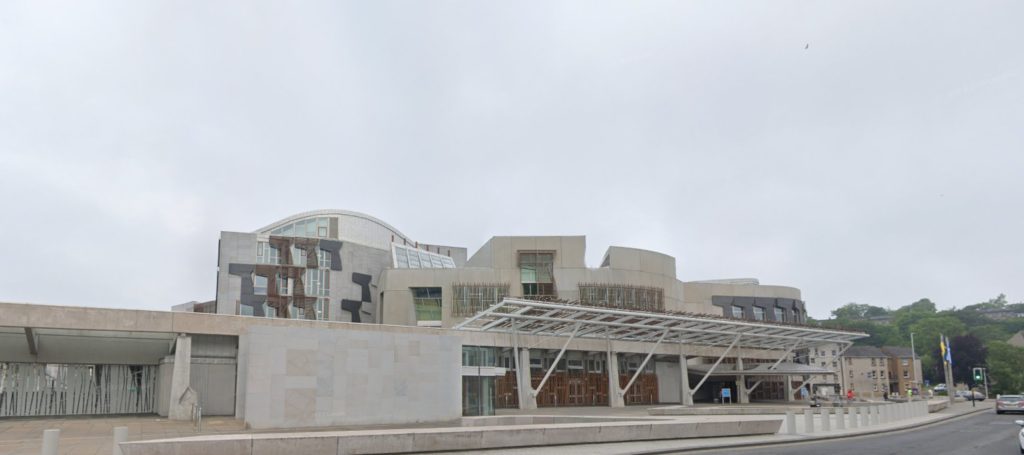 An image of a modern white building with a glass canopy at the front.