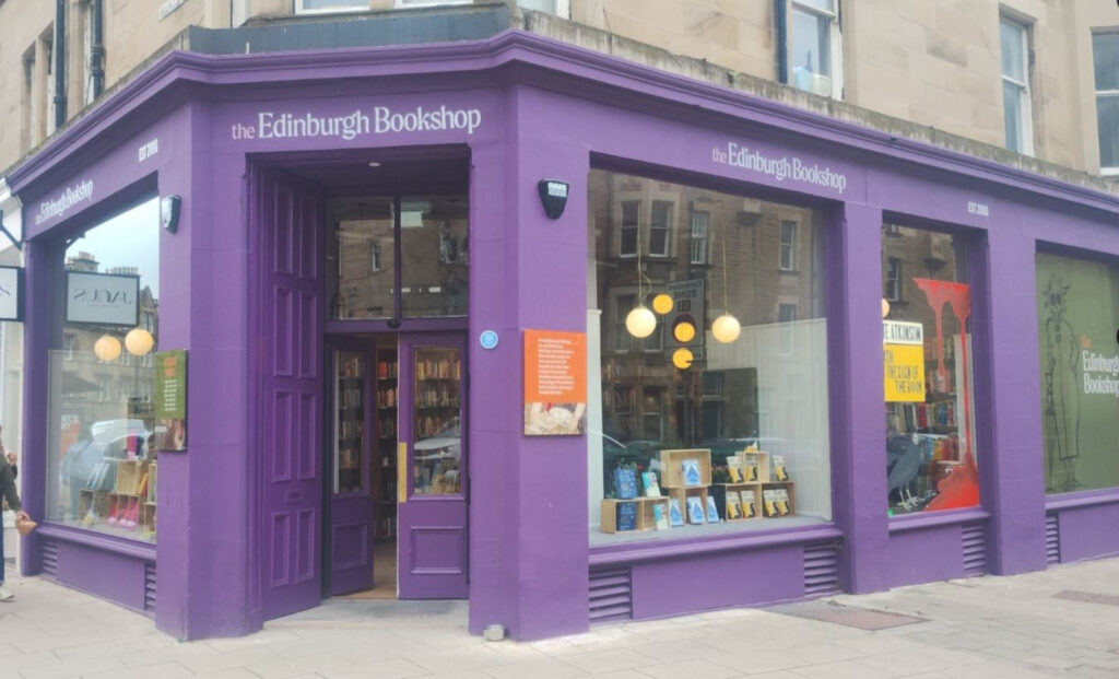 An image of a shopfront on a street corner, painted purple.