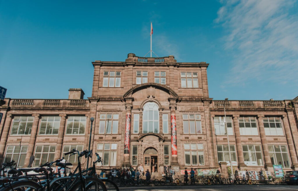 An image of a grand old building with columns and several large windows.