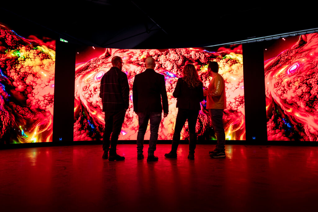 A group of people lined up admiring an exhibit in the CoSTAR Realtime Lab.