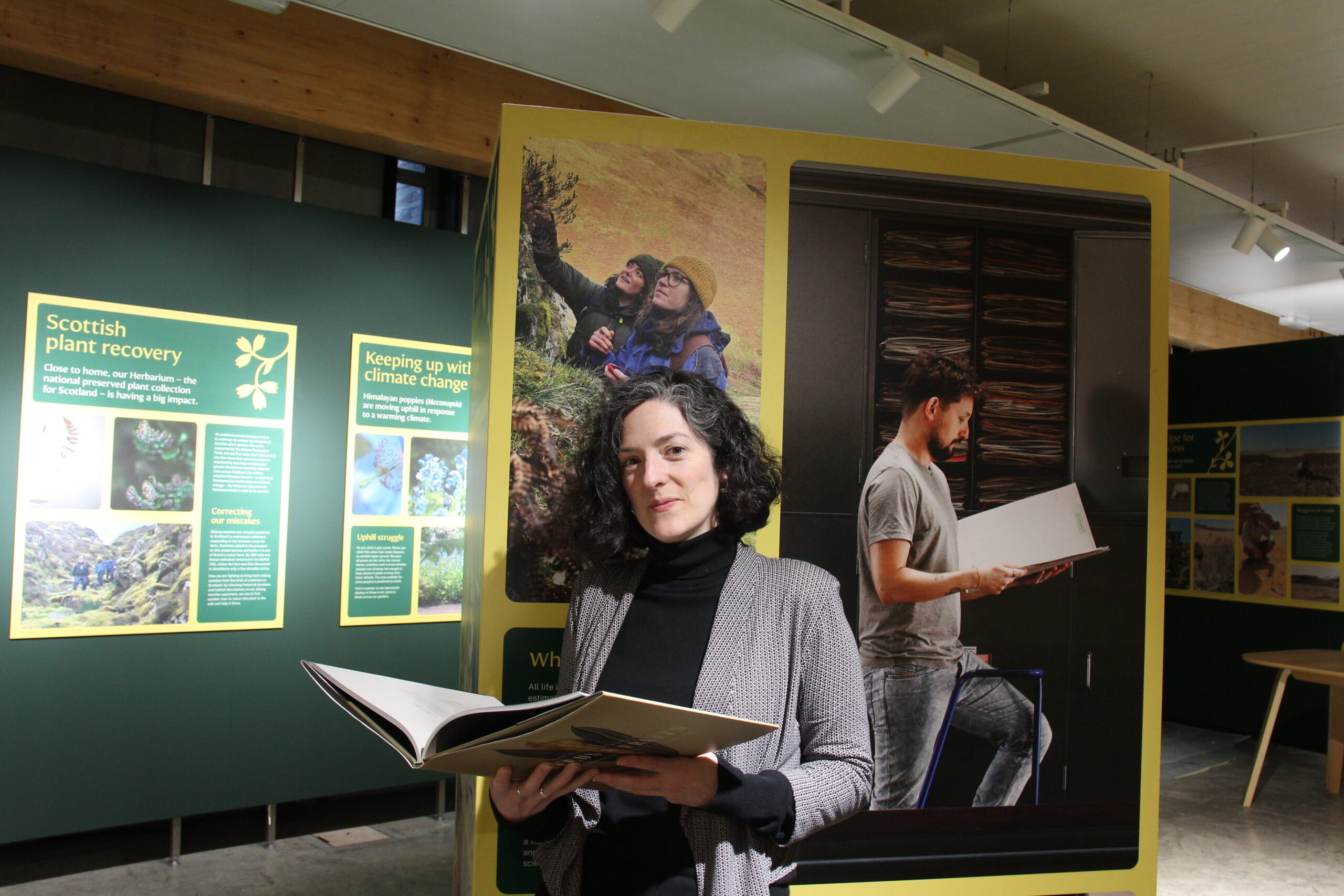 A woman standing in front of the Pressed for Time exhibition.